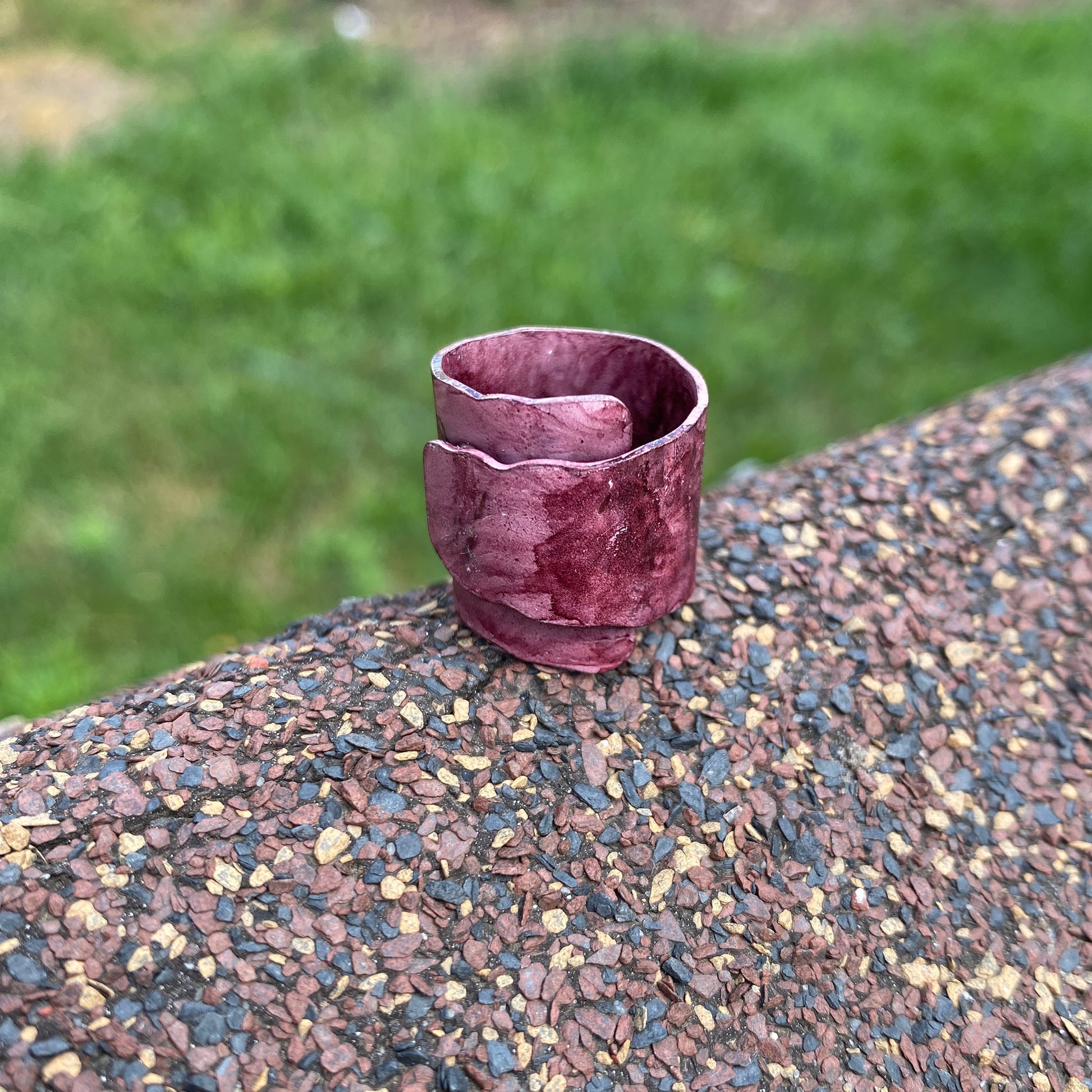 Patina ring Sonata standing outdoors with an artisanal burgundy-violet finish