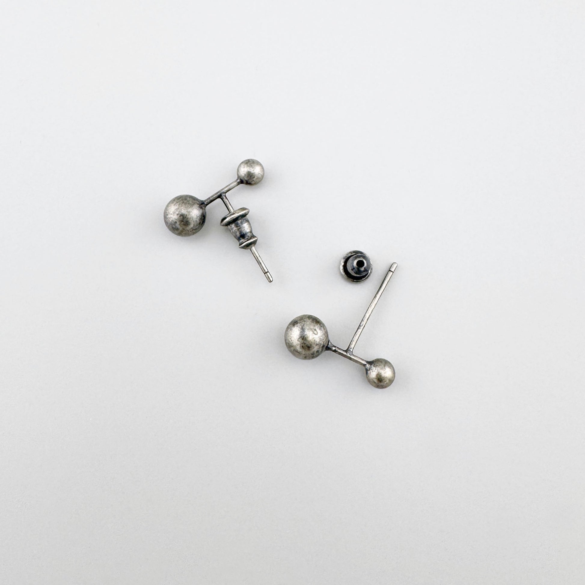 Silberohrringe mit Patina 925, zwei Kugeln in unterschiedlichen Größen, ruhiger minimalistischer Flatlay