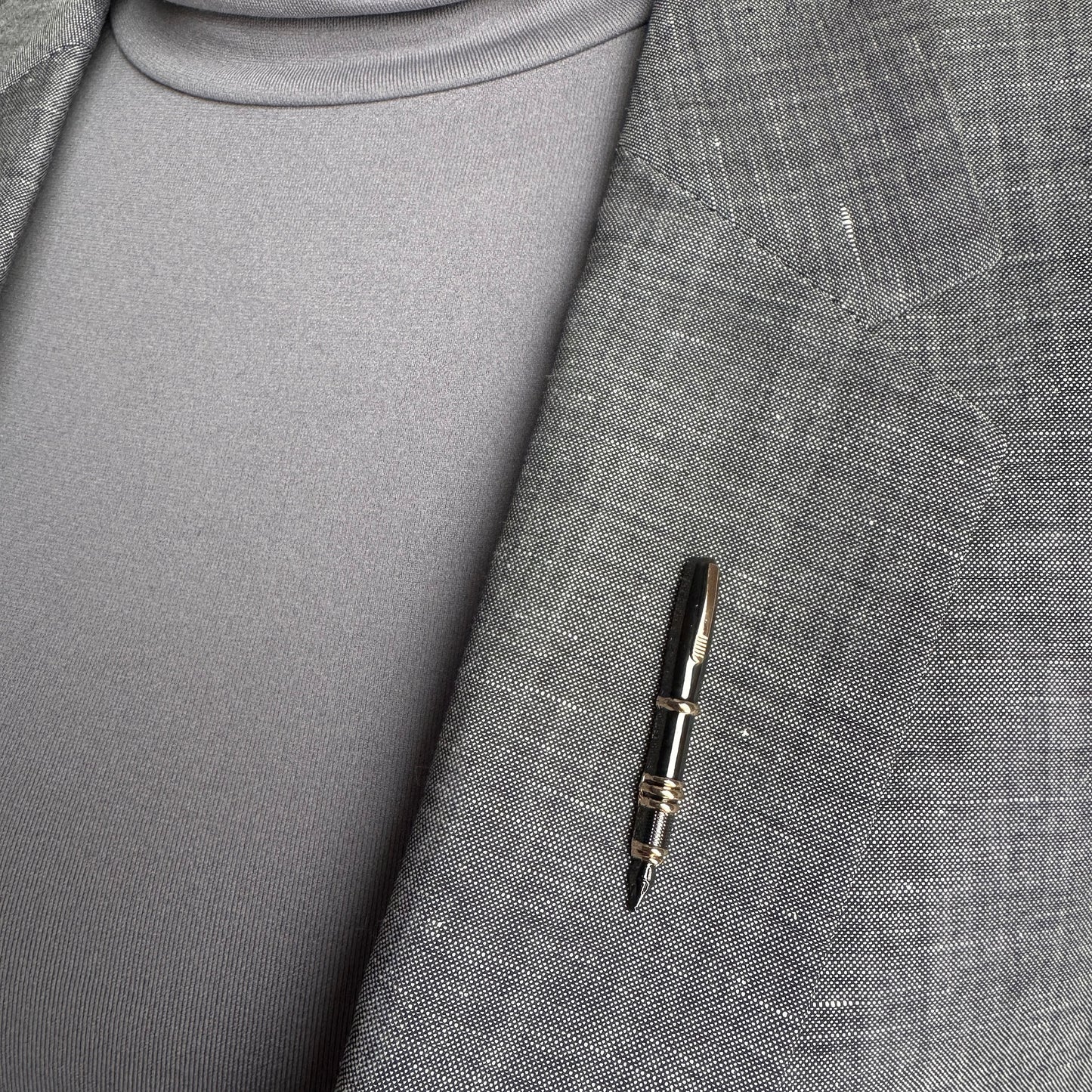 Elegant pen brooch Sonata worn on a blazer with metallic shine and gold accents