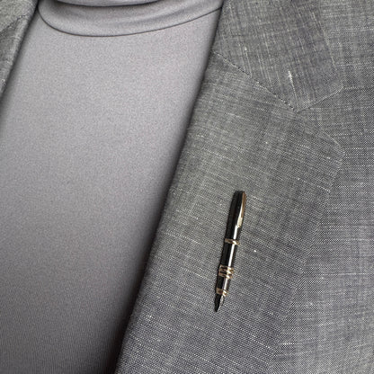 Elegant pen brooch Sonata worn on a blazer with metallic shine and gold accents
