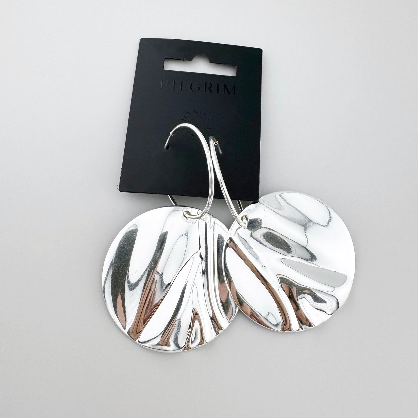 Duże kolczyki dyski Pilgrim z lustrzaną, falującą powierzchnią i rzeźbiarskim efektem