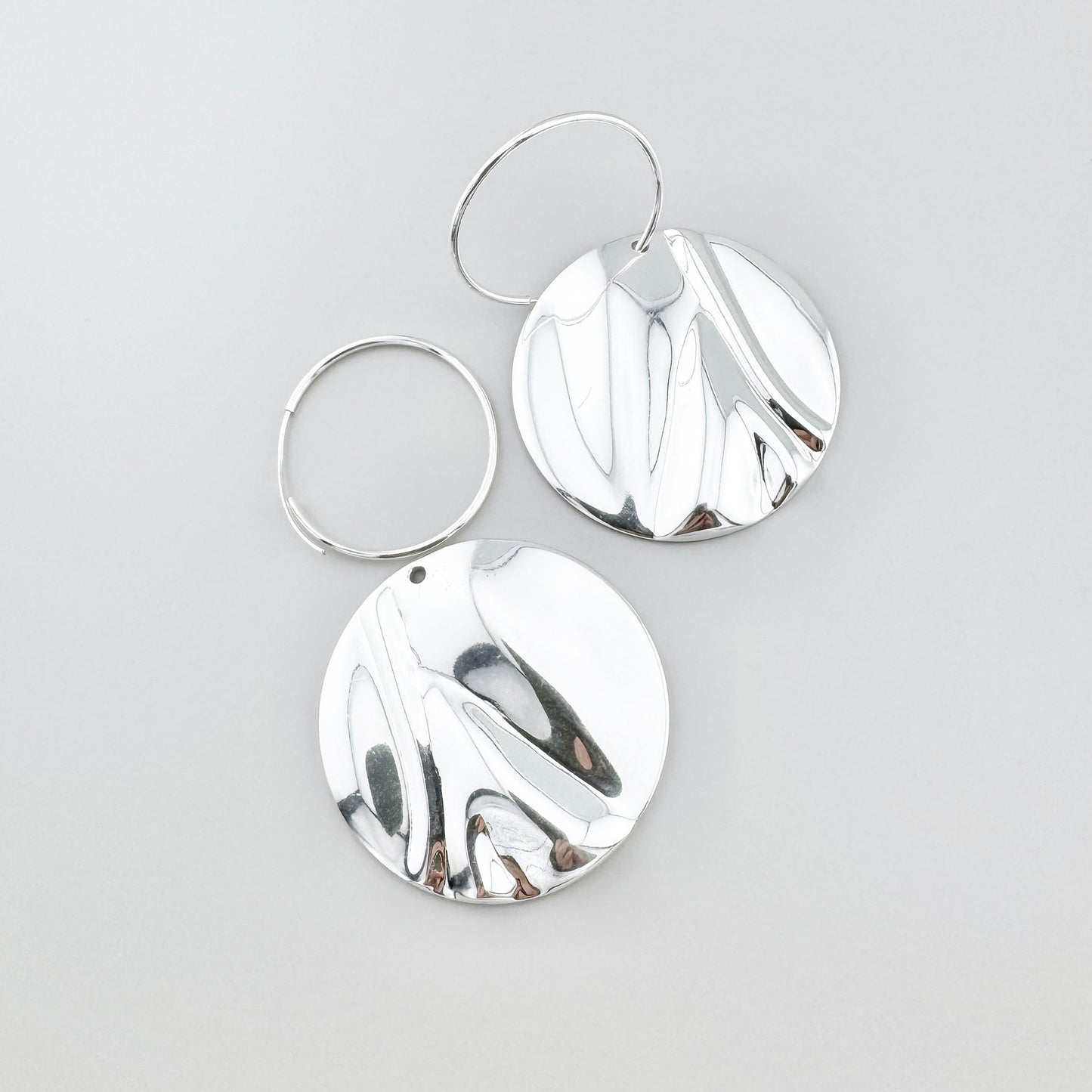 Boucles disques Pilgrim, surface miroir et relief ondulé créant un jeu vivant de reflets