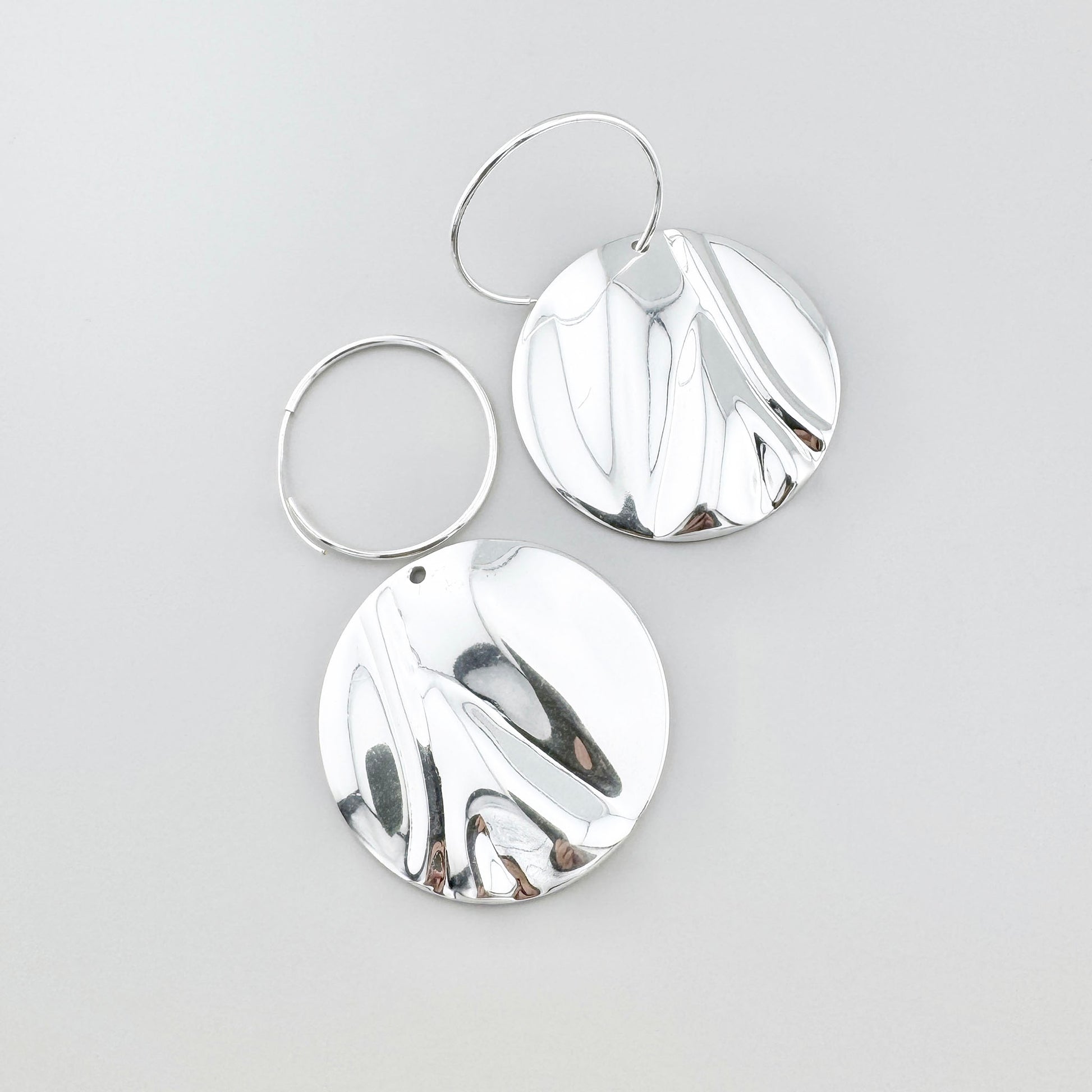 Boucles disques Pilgrim, surface miroir et relief ondulé créant un jeu vivant de reflets