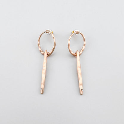 Długie kolczyki Pilgrim w ciepłym złocie z młotkowaną fakturą i drobnym kryształem na końcu