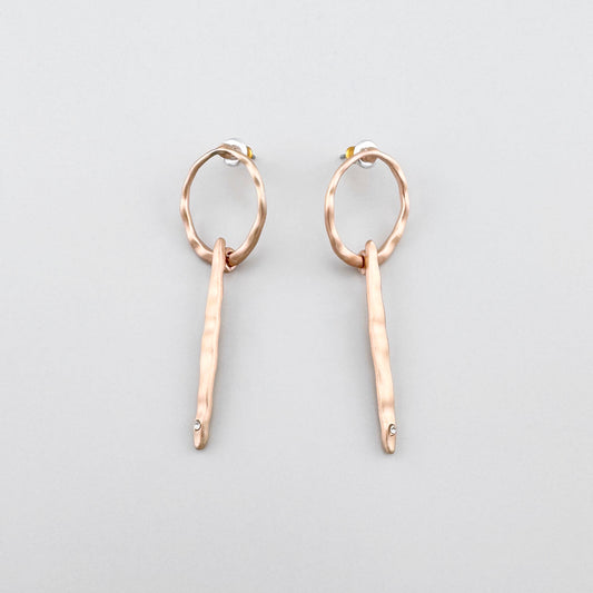 Długie kolczyki Pilgrim w ciepłym złocie z młotkowaną fakturą i drobnym kryształem na końcu