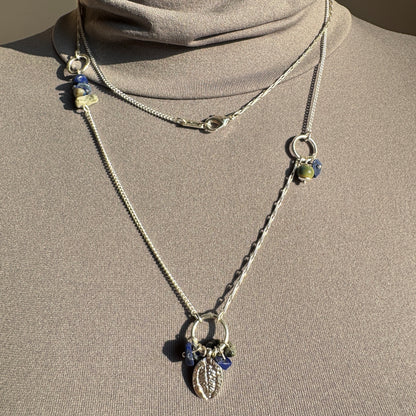 Pilgrim necklace with leaf charm and cobalt blue stones layered on mannequin