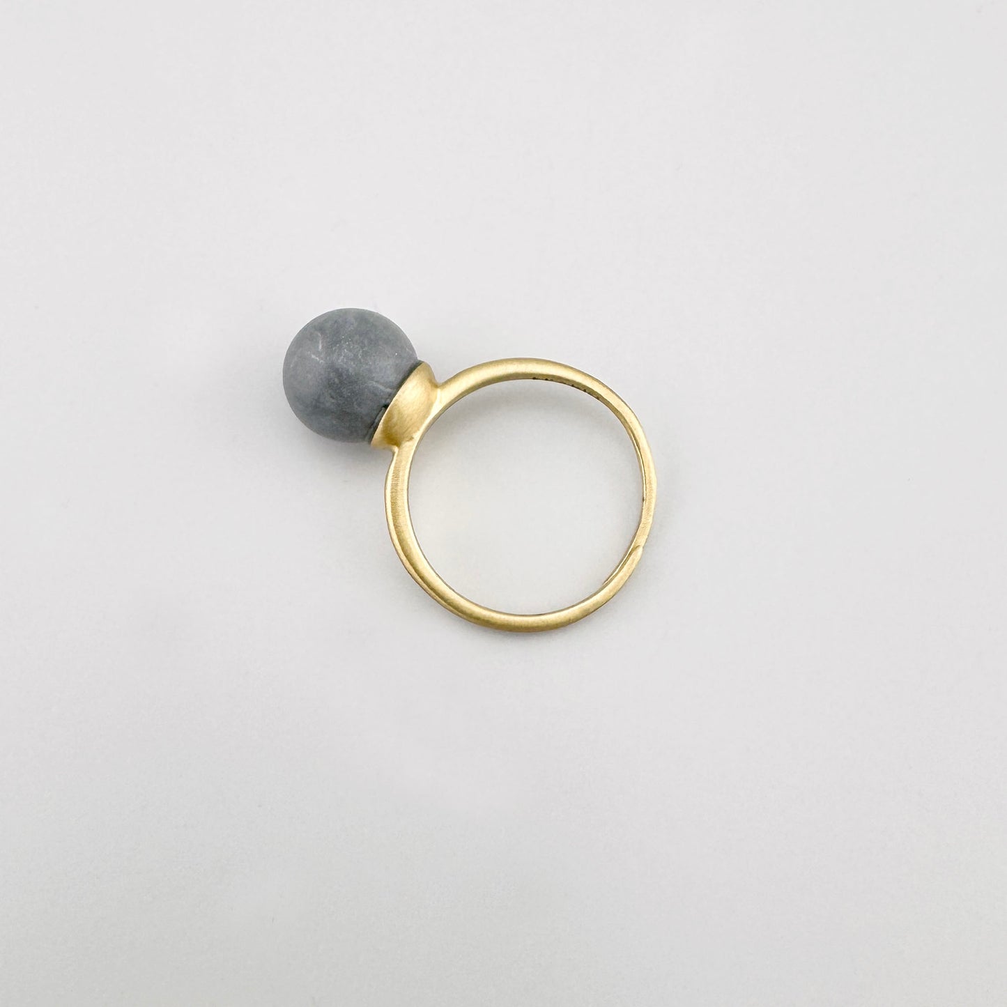 Bague Pilgrim dorée avec pierre grise mate sur fond clair