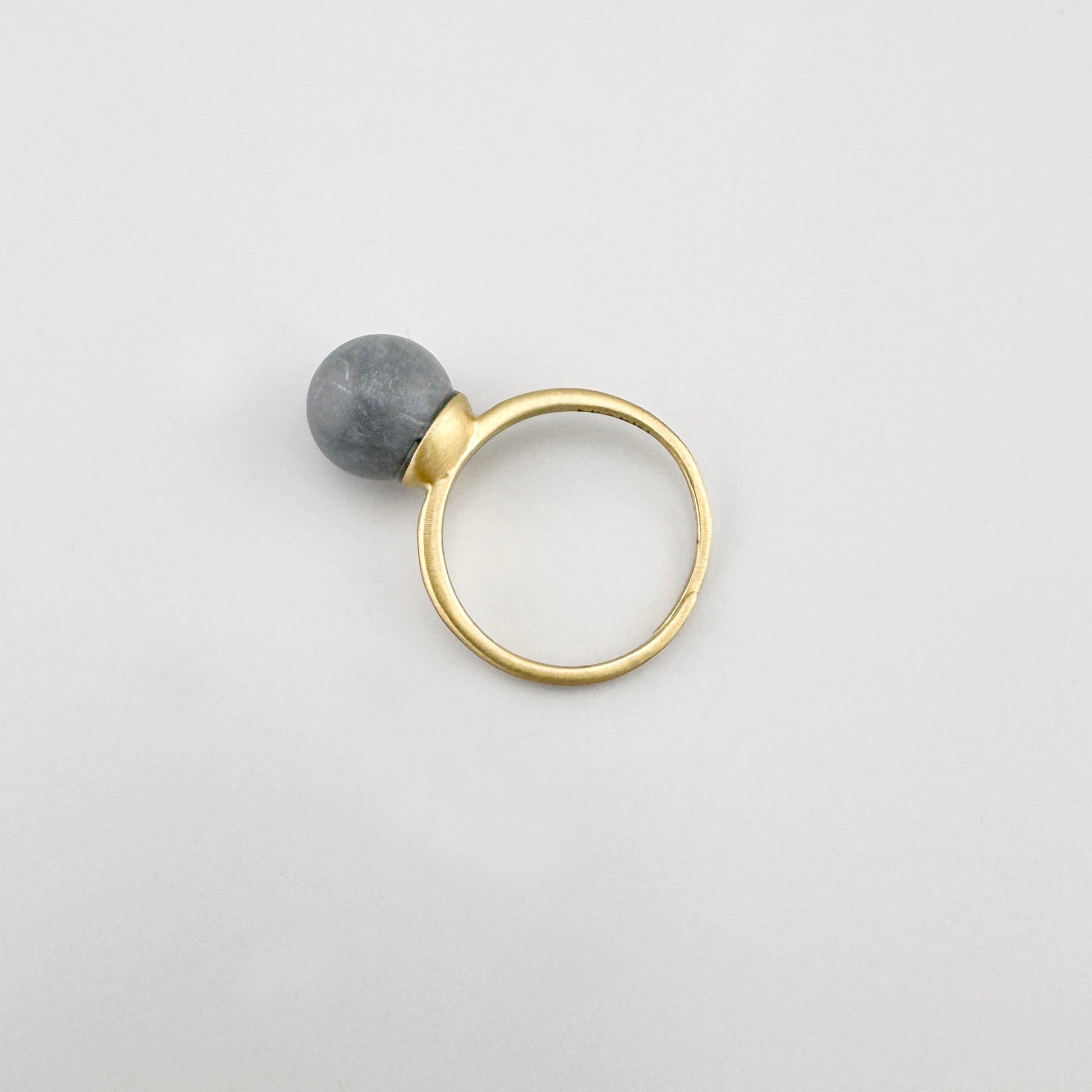 Bague Pilgrim dorée avec pierre grise mate sur fond clair