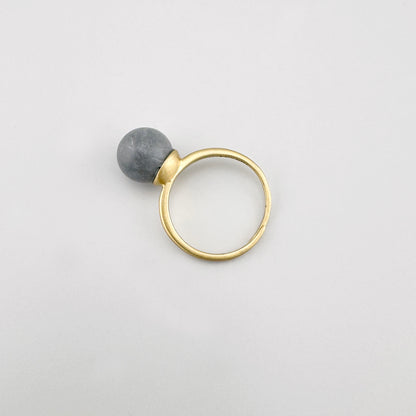 Bague Pilgrim dorée avec pierre grise mate sur fond clair