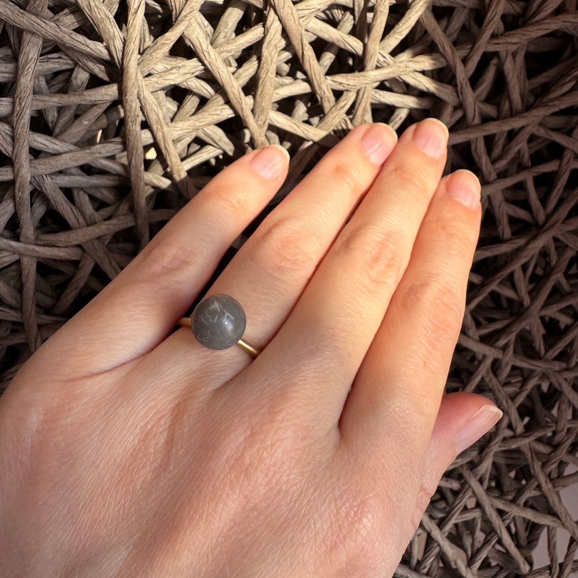 Adjustable Pilgrim ring worn with a matte gray stone and satin finish