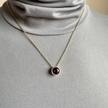 Purple quartz necklace worn at the neckline on a delicate gold-tone chain