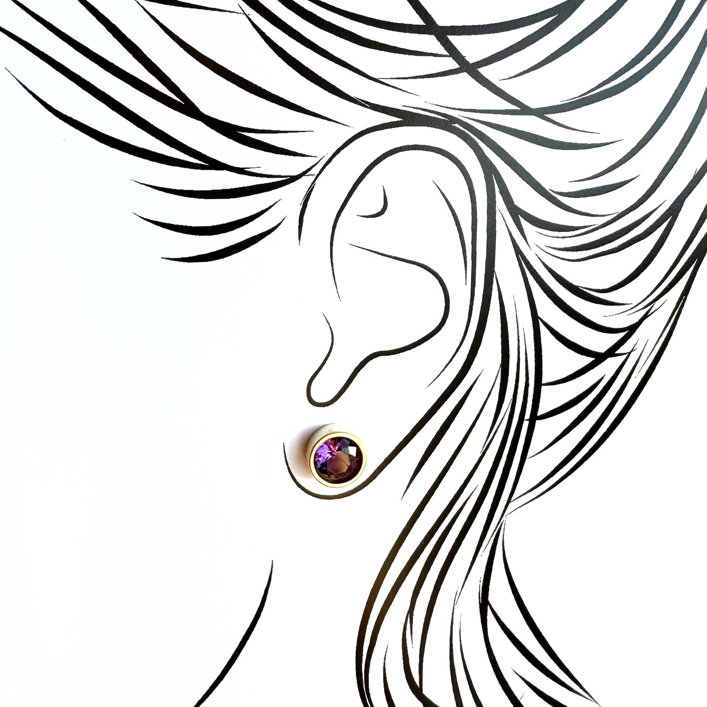 Silver quartz stud earrings worn on ear with subtle light reflection