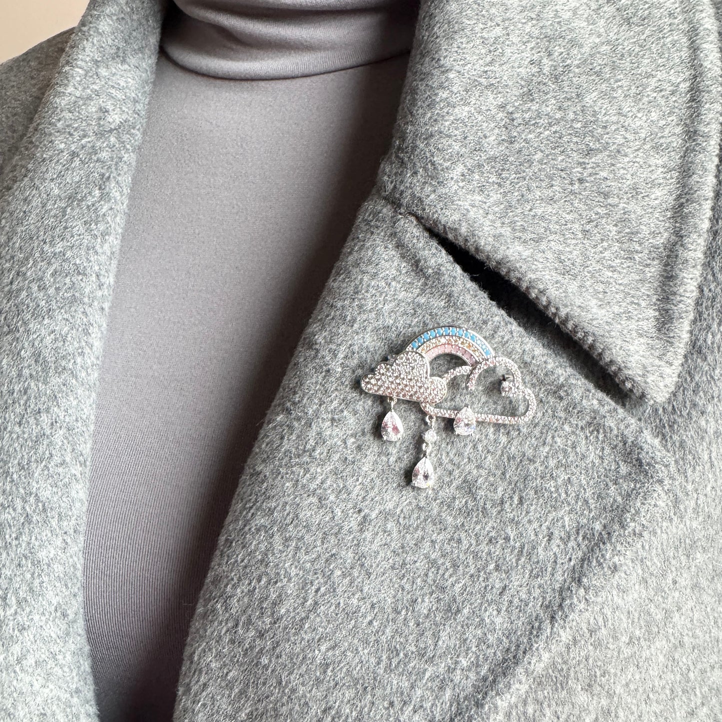 Rainbow cloud brooch Maravillas worn on a coat with crystal drops