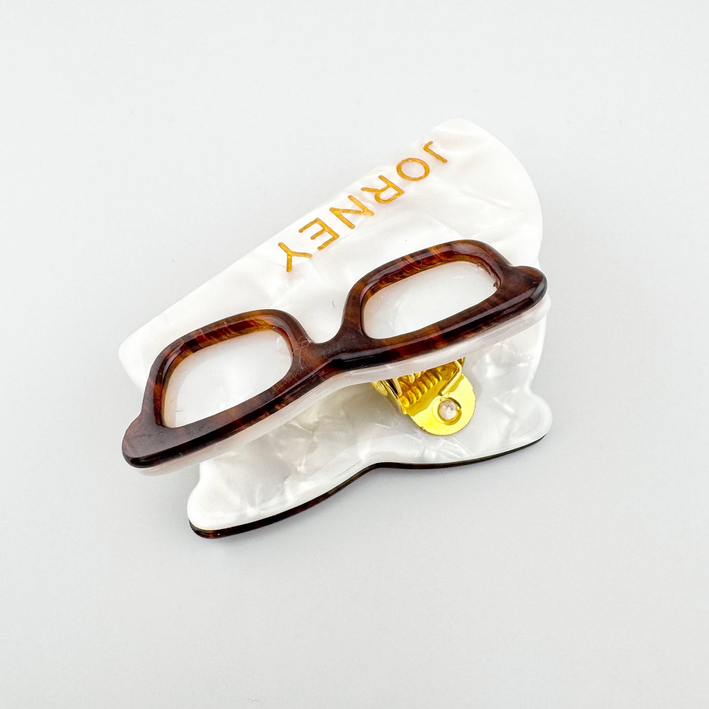 Pince à cheveux nacrée avec décor lunettes et détail doré