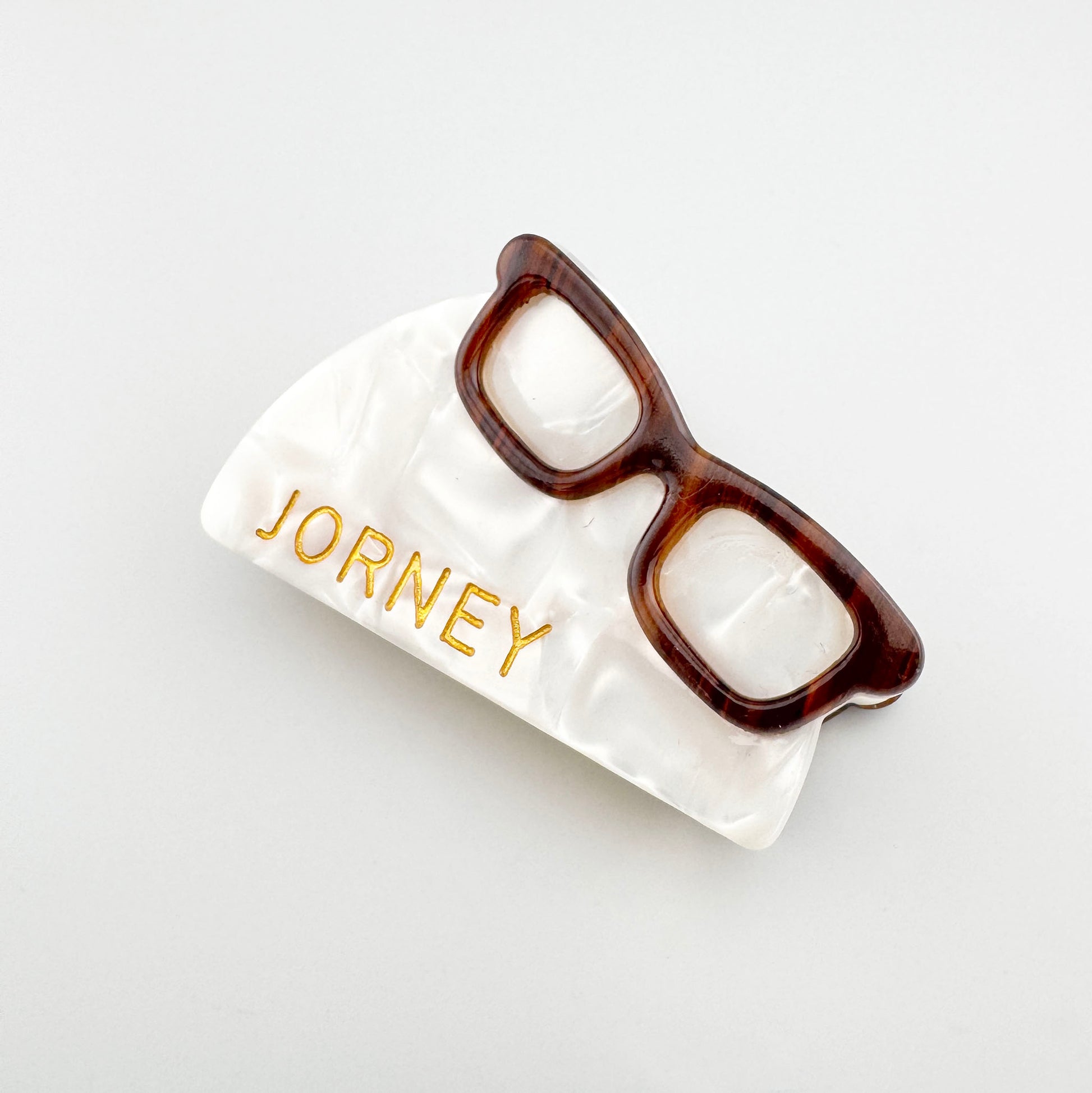 Retro hair claw with a pearly finish and decorative glasses detail