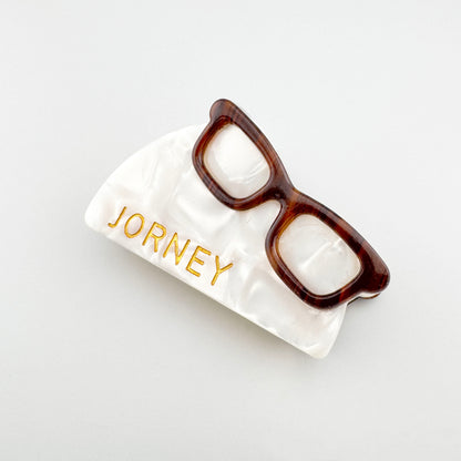 Retro hair claw with a pearly finish and decorative glasses detail