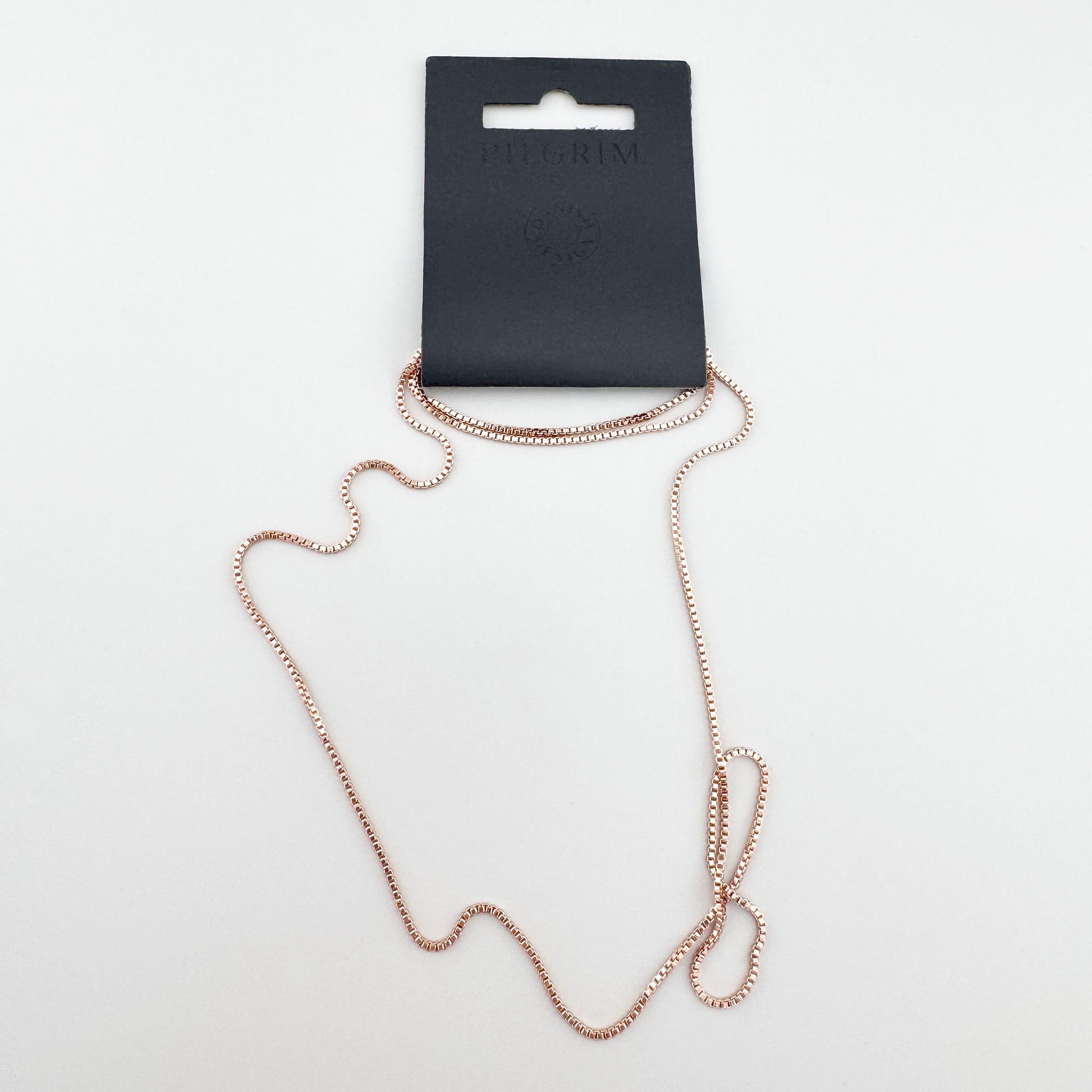 Collier minimaliste Pilgrim en or rose présenté dans l’emballage de la marque