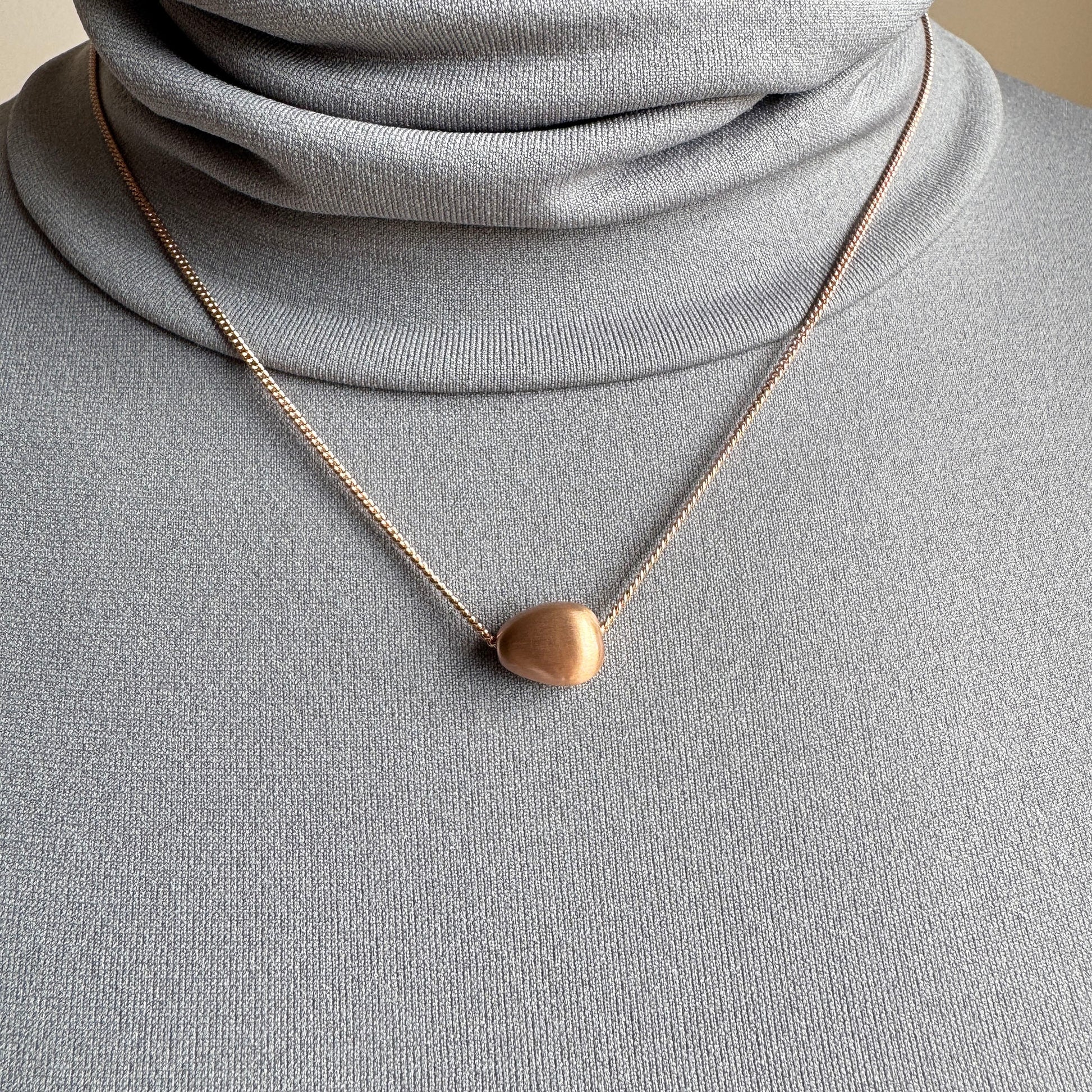Rose gold Pilgrim necklace with soft matte oval pendant worn delicately
