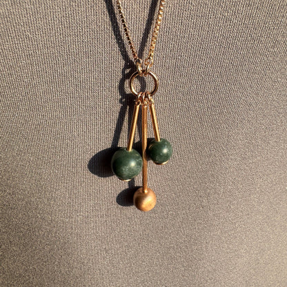 Collier doré rose avec perles vertes et design moderne