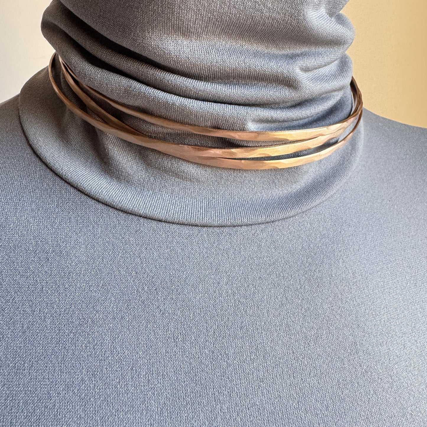 Rose gold open necklace worn close to the neck with a sculptural line