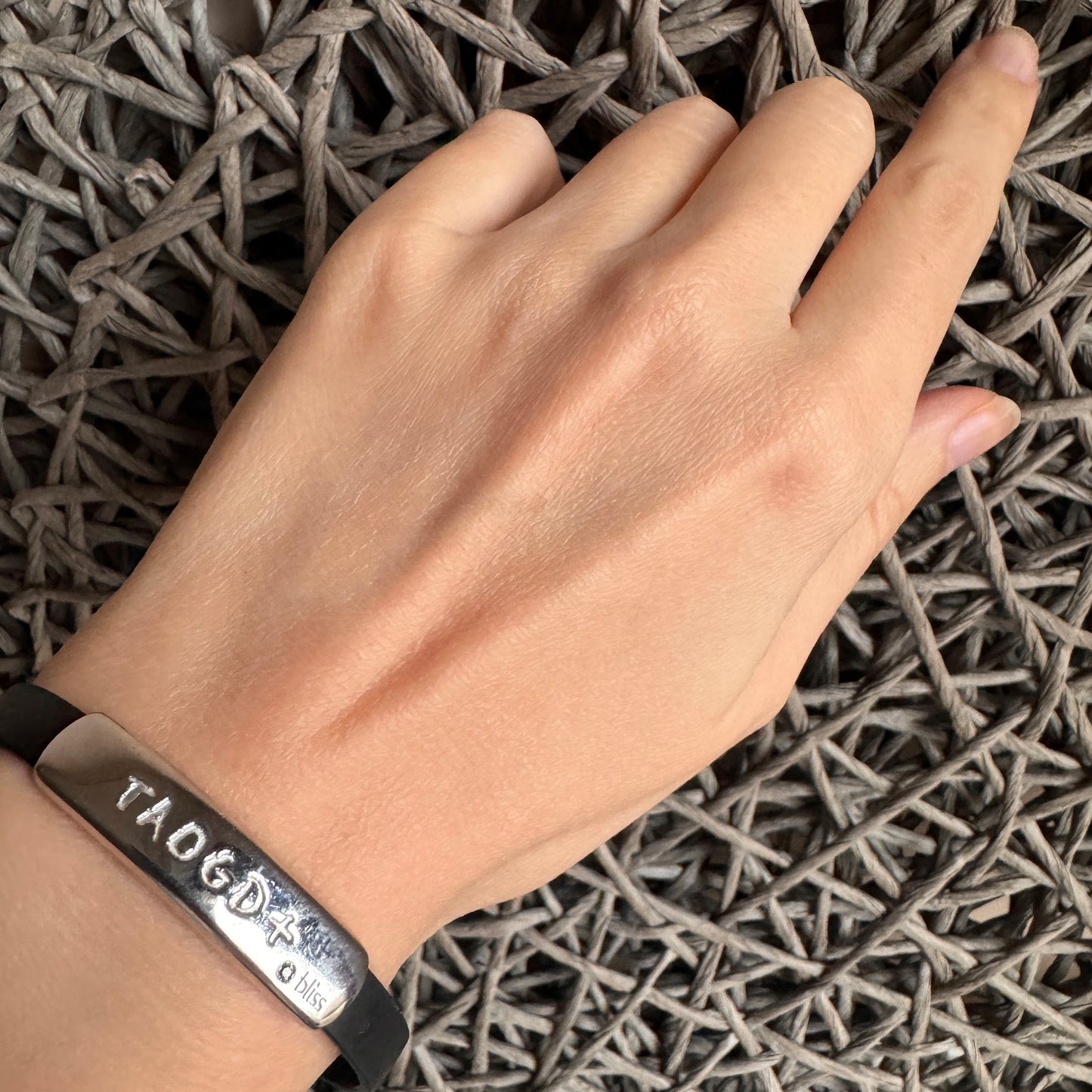 Silver and rubber bracelet worn on the wrist with a clean engraved detail