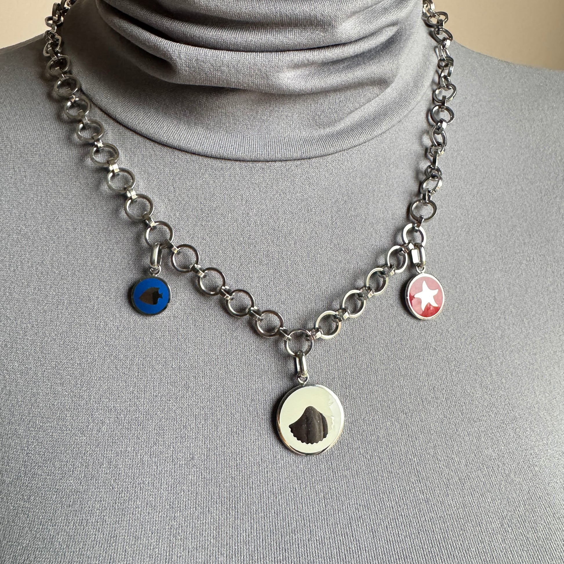 Color medallion necklace worn on the neck with a bold silver chain
