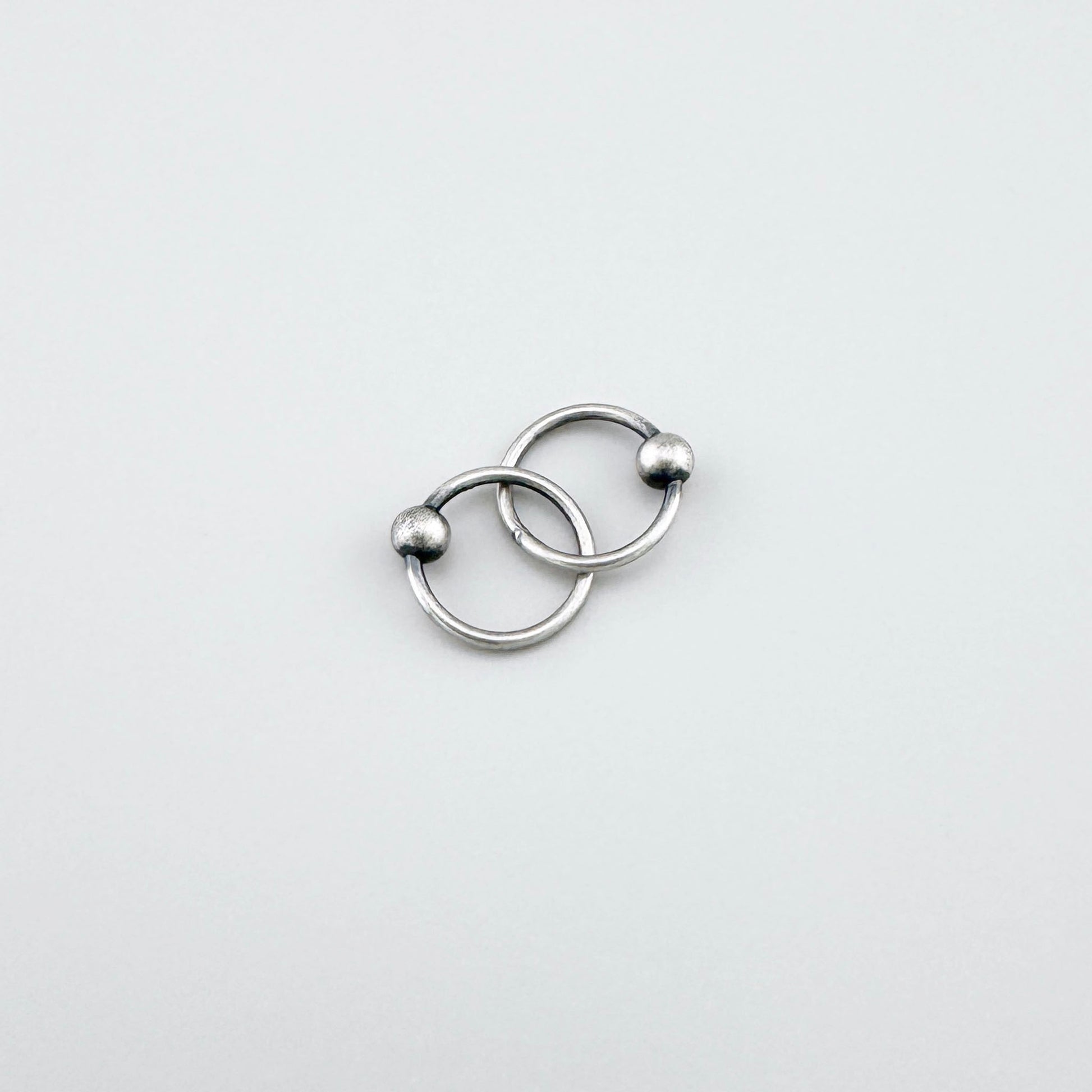 Elegant LULU Copenhagen silver piercer hoops with small polished ball detail