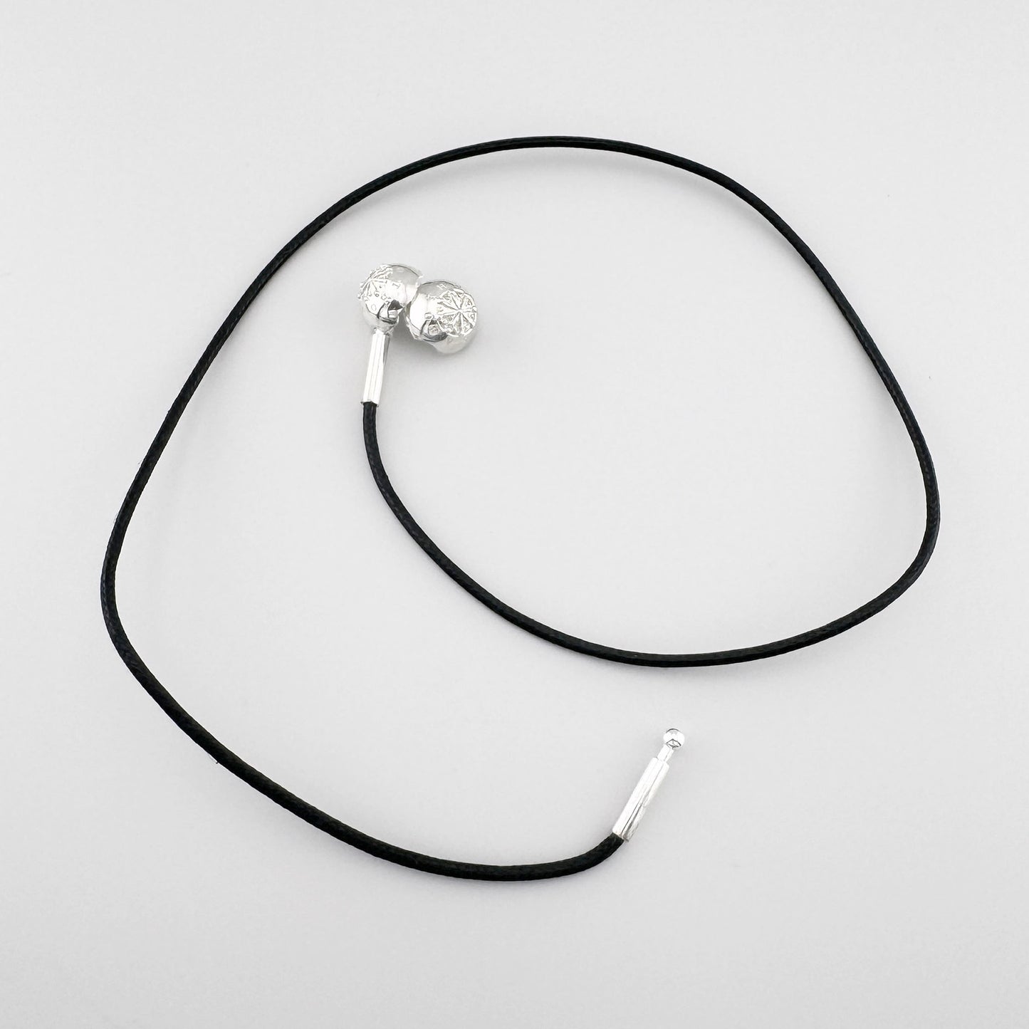 Choker noir Thomas Sabo avec boule en argent et fermoir visible sur fond clair
