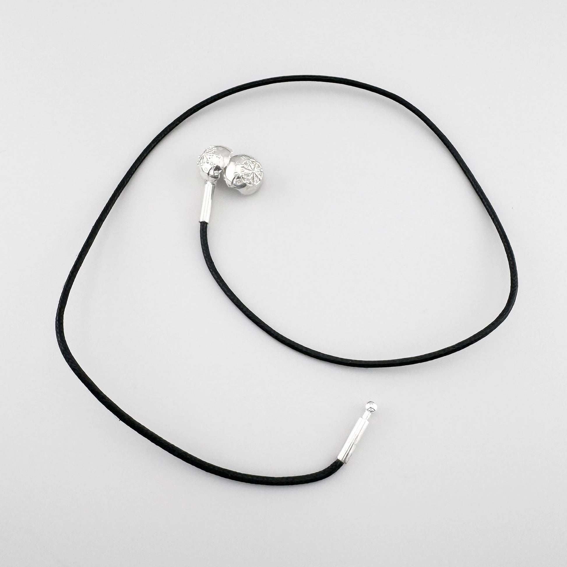 Choker noir Thomas Sabo avec boule en argent et fermoir visible sur fond clair