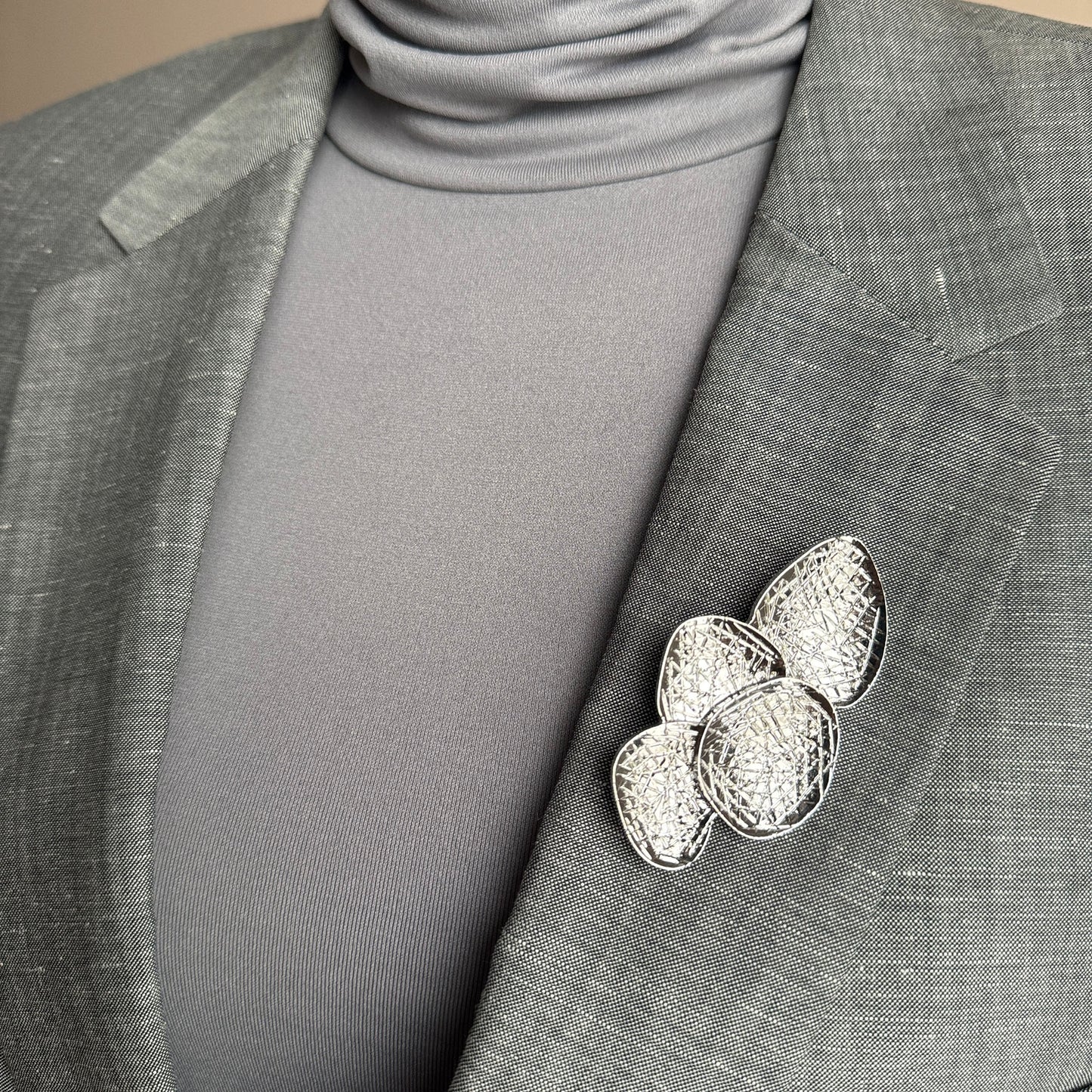 Silver disc brooch Sonata worn on a blazer with a textured layered design