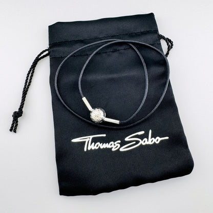 Black cord choker by Thomas Sabo with a silver compass bead displayed on a branded pouch