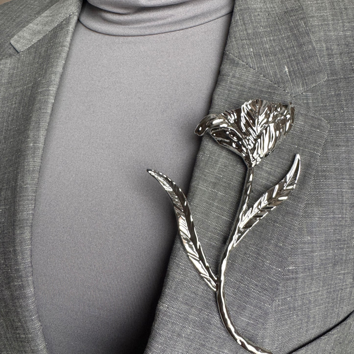 Modern silver flower brooch Sonata worn on a blazer with an organic sculptural shape