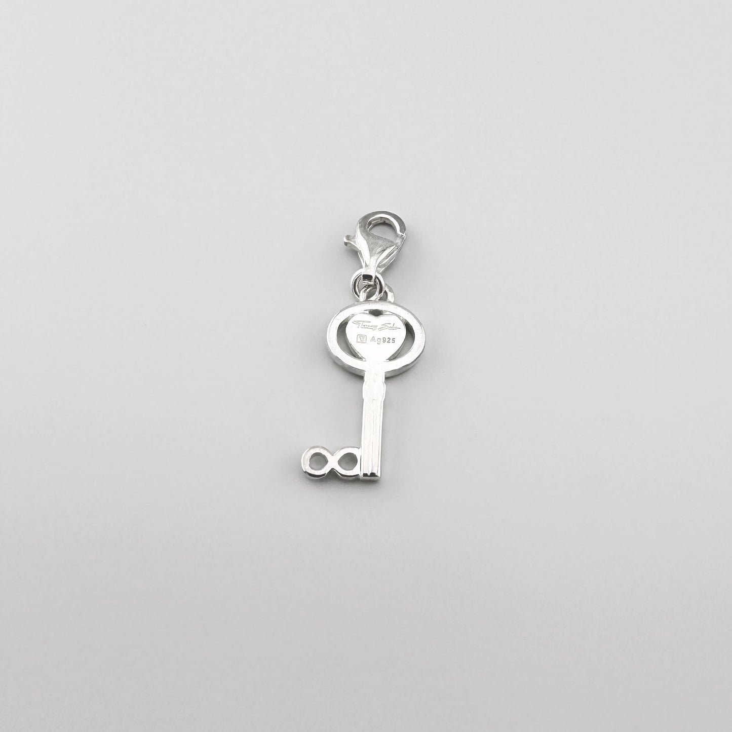 Silberner Schlüssel-Charm mit Herz von Thomas Sabo auf hellem Hintergrund