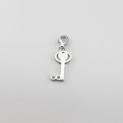 Silberner Schlüssel-Charm mit Herz von Thomas Sabo auf hellem Hintergrund