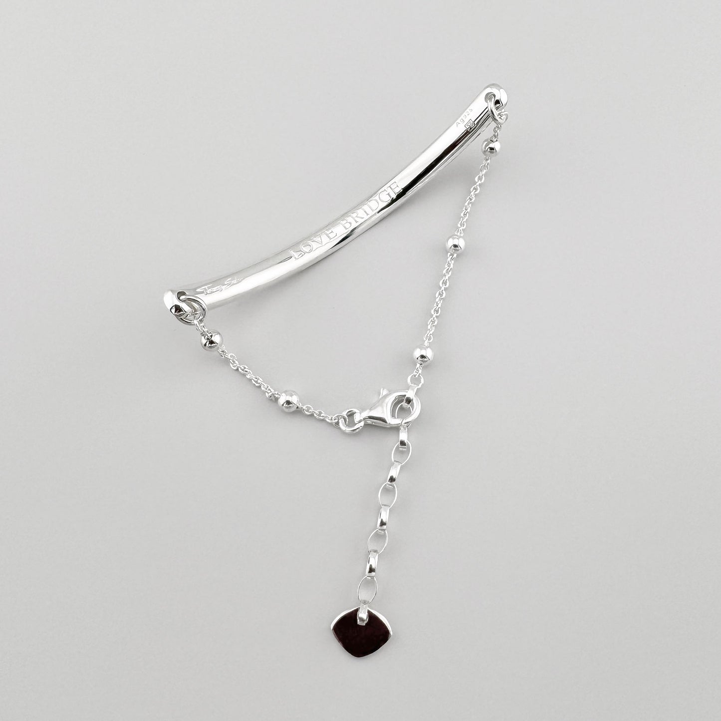 Silbernes Love Bridge Armband von Thomas Sabo mit gebogener Gravurplatte und schwarzem Herzanhänger