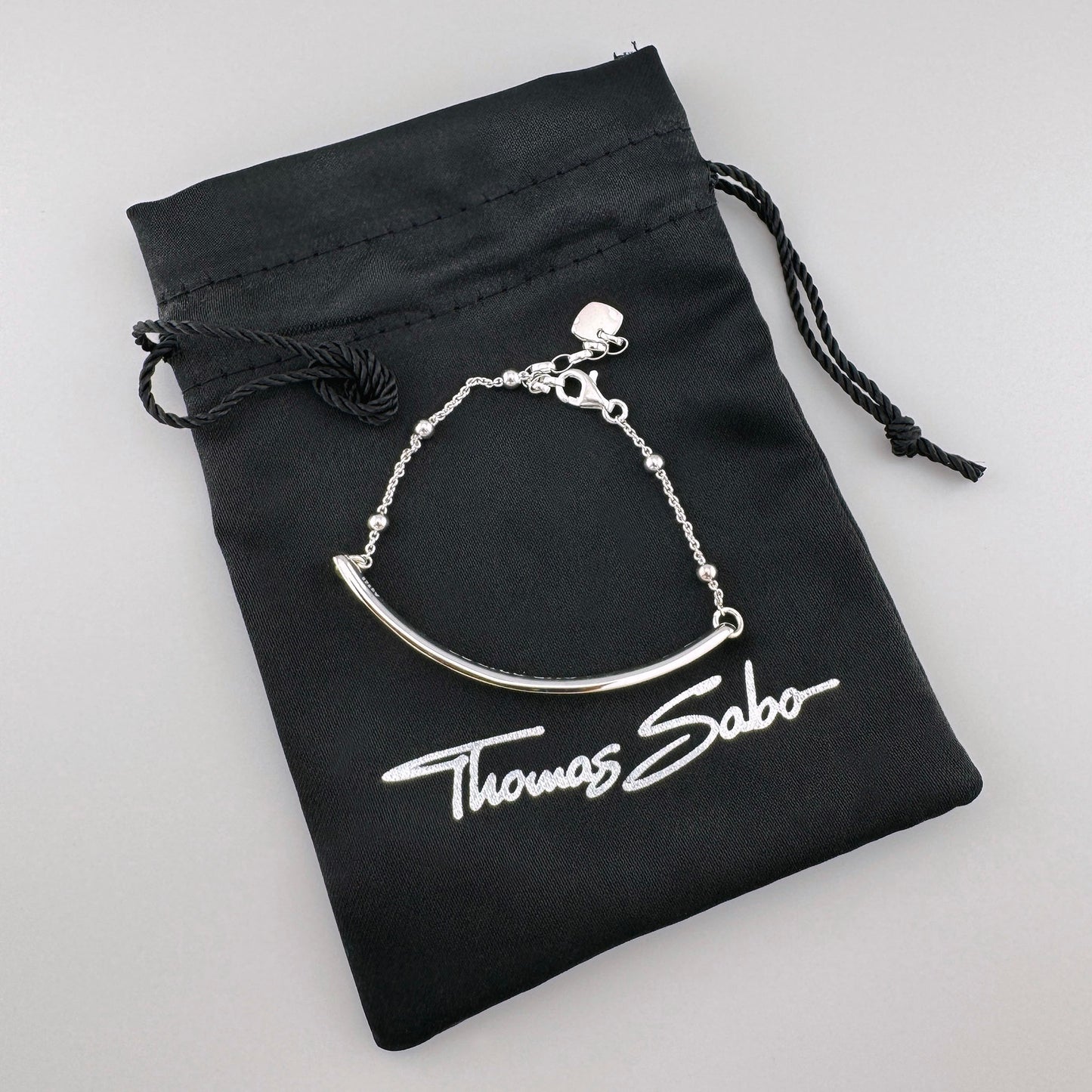 Srebrna bransoletka Love Bridge Thomas Sabo z polerowaną belką przy firmowym woreczku
