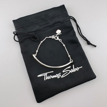 Srebrna bransoletka Love Bridge Thomas Sabo z polerowaną belką przy firmowym woreczku