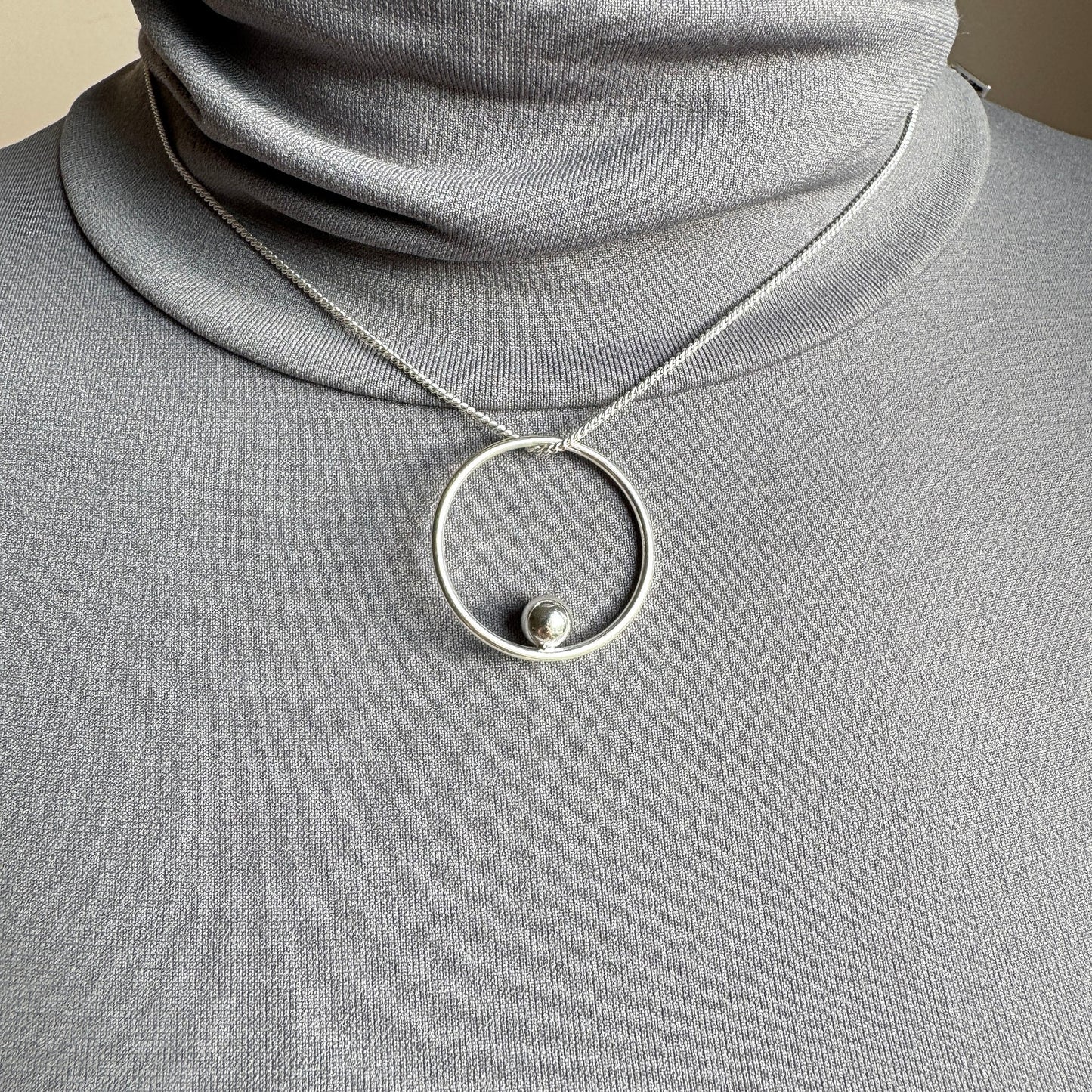 Elegant silver necklace with circle pendant and small bead for modern looks