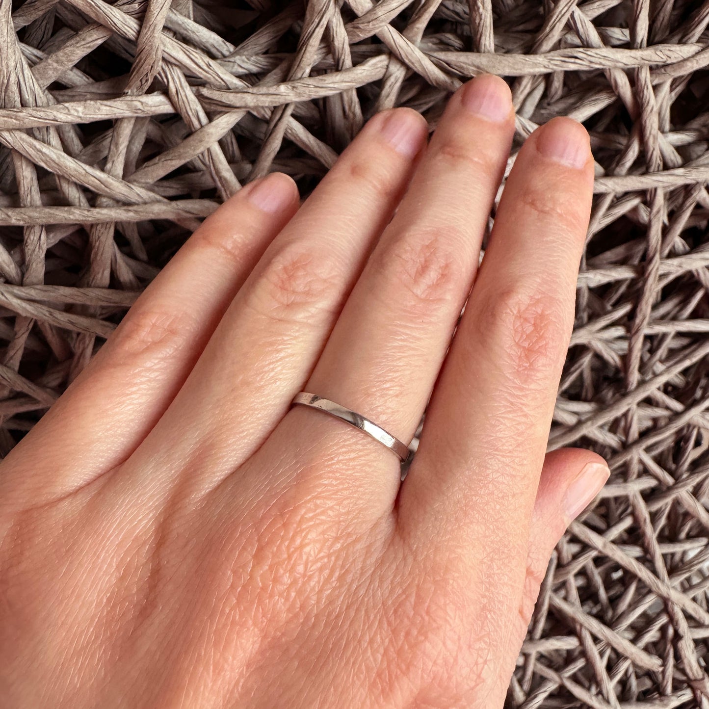 Bague argentée minimaliste Universe portée à la main avec ligne fine et épurée