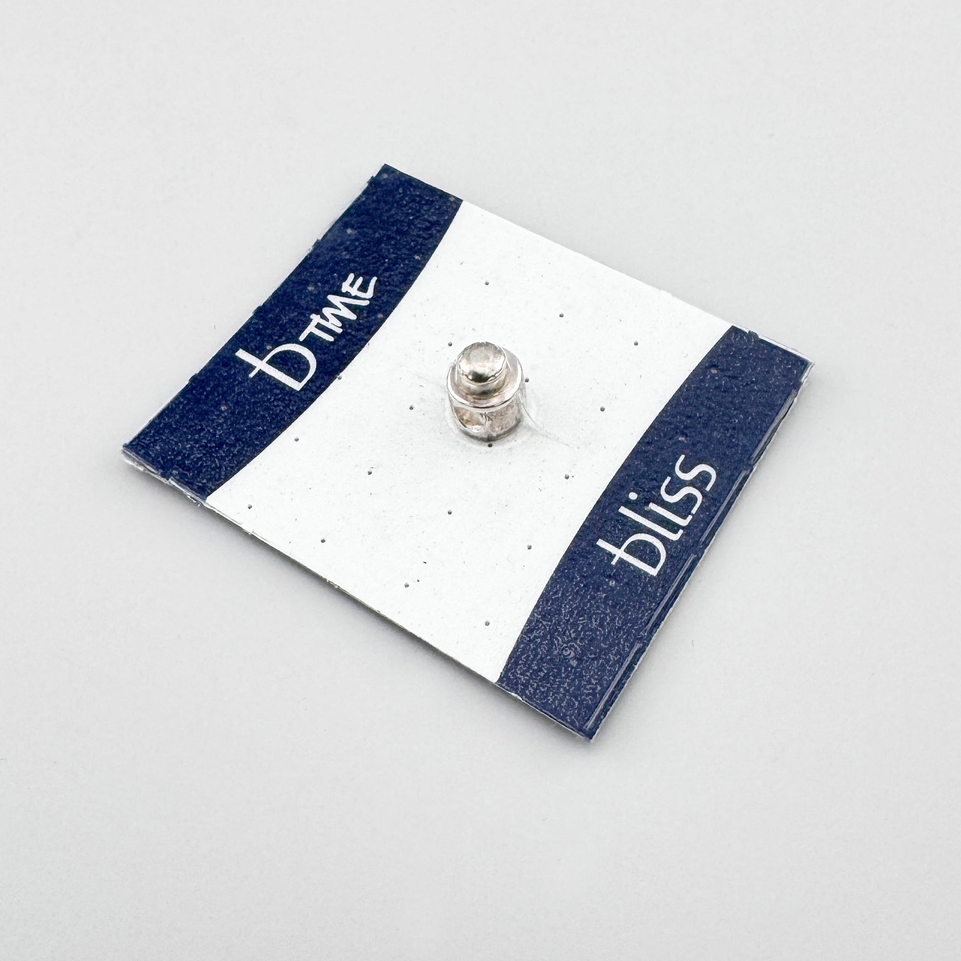 Silver screw charm by Bliss Gioielli displayed on a branded card