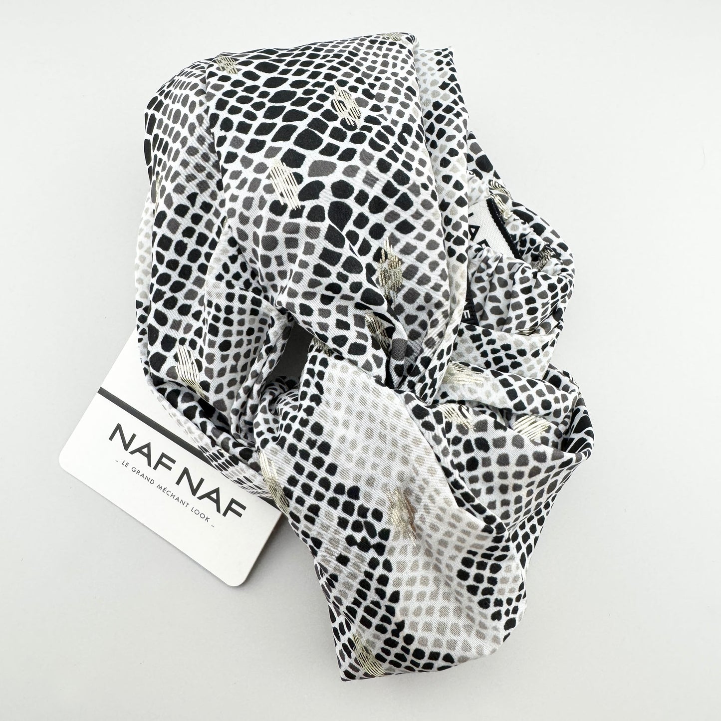 Black and white Naf Naf headband with a subtle gold shimmer and elastic back
