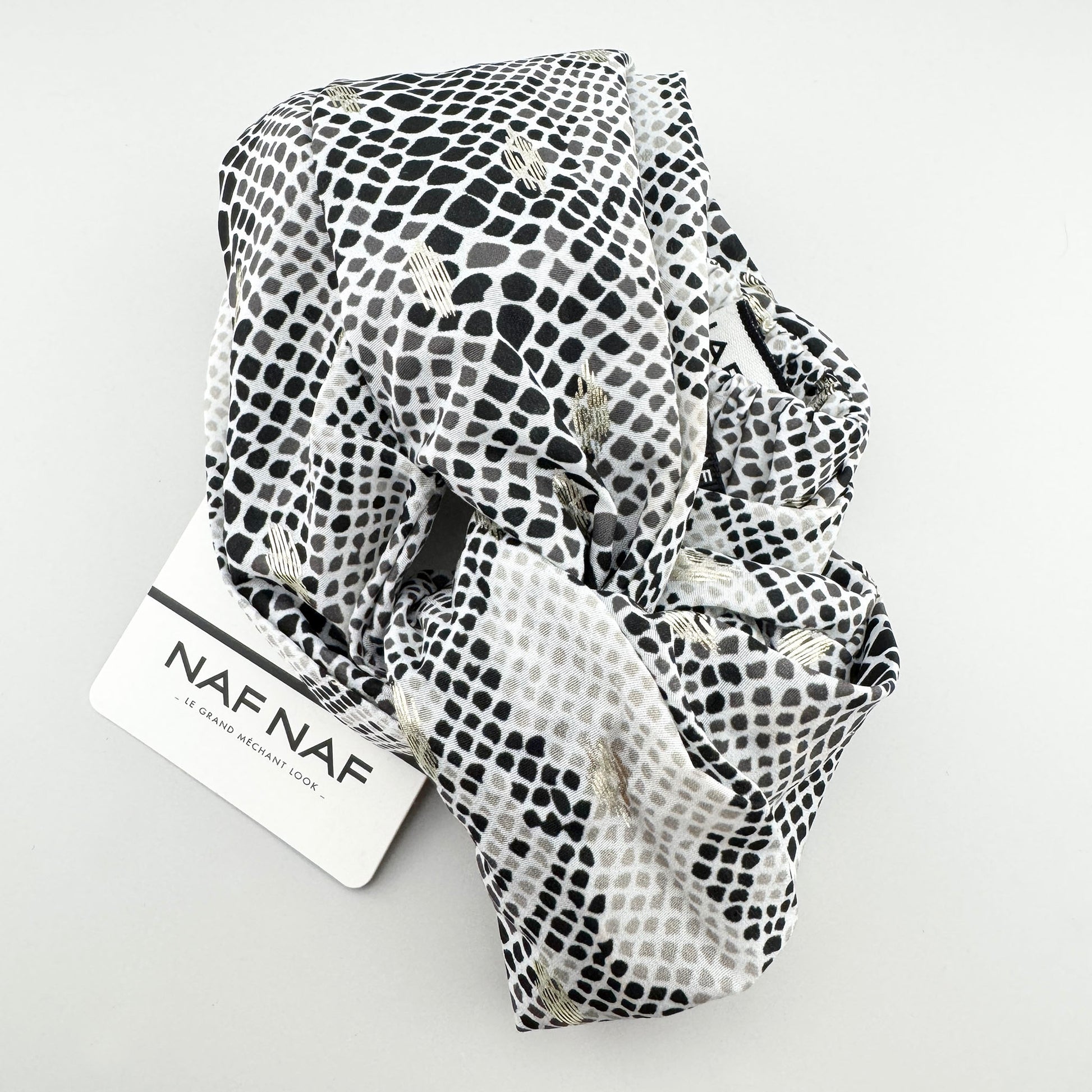 Black and white Naf Naf headband with a subtle gold shimmer and elastic back