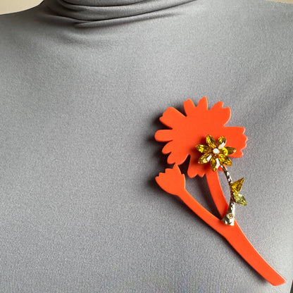 Orange flower crystal brooch by Sonata pinned to clothing for a bright accent