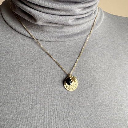 Gold star and medallion necklace IRL worn on the neck with a delicate layered look