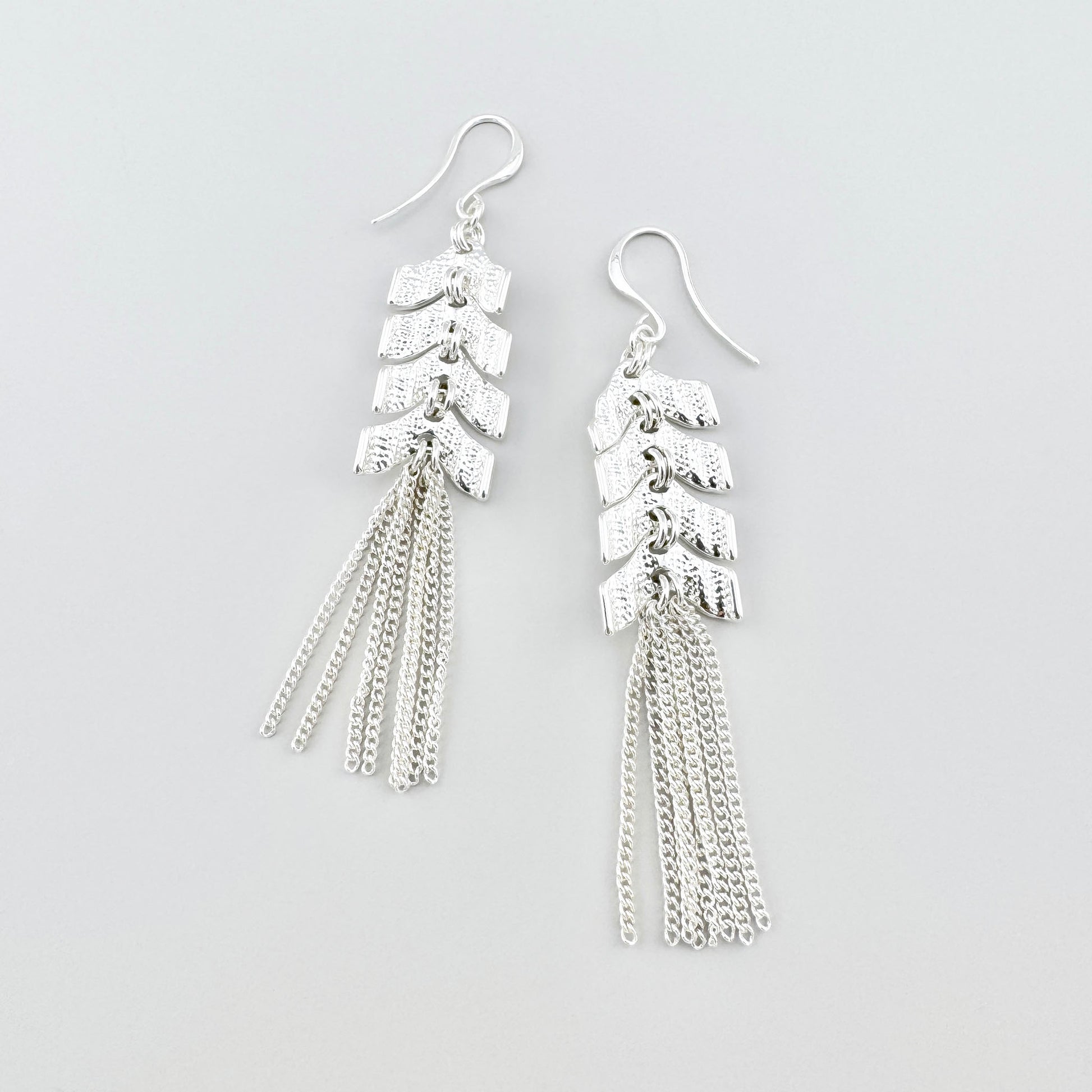 Довгі сережки з китицями Pilgrim, тонкі ланцюжки та елементи-«стрілки», вільне мерехтіння й рух