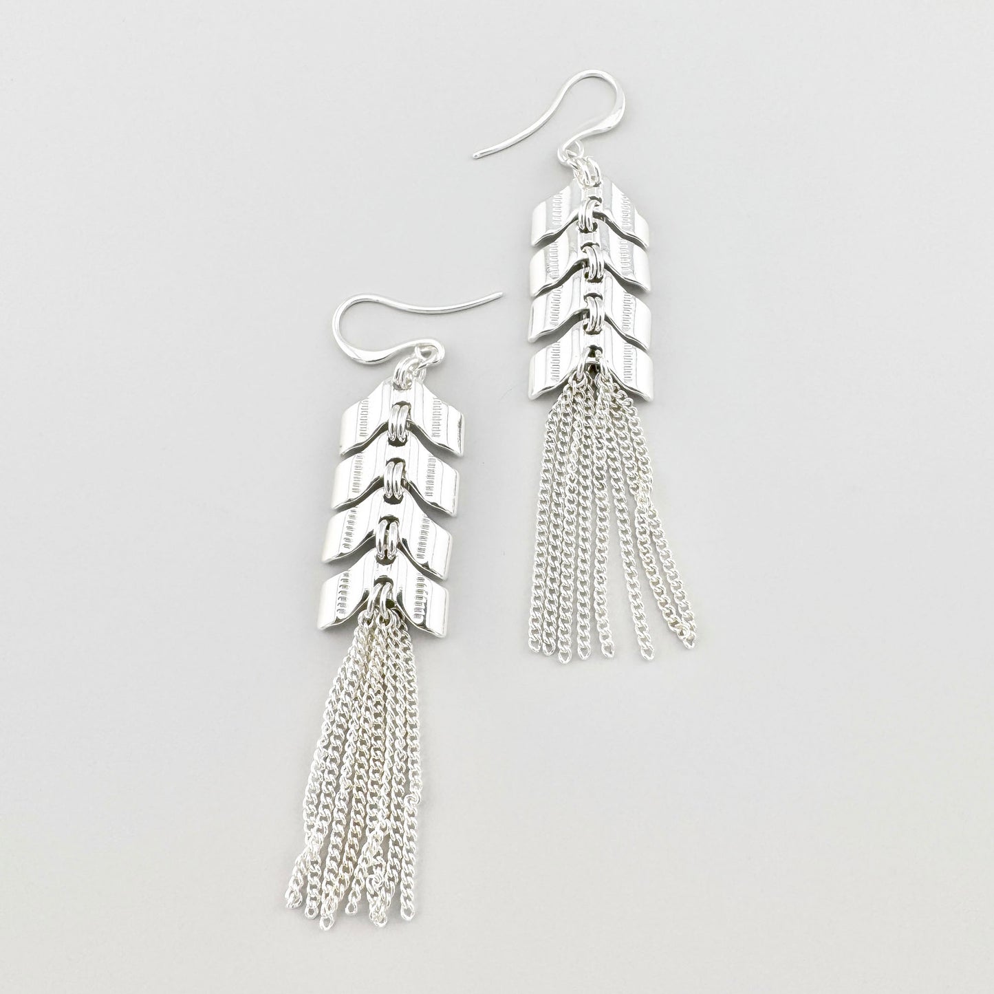 Długie kolczyki z frędzlami Pilgrim, cienkie łańcuszki, elementy jak strzałki i lustrzany połysk