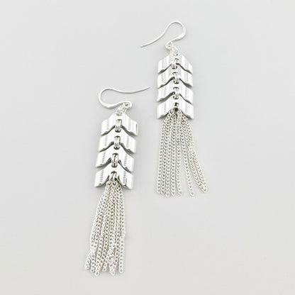 Długie kolczyki z frędzlami Pilgrim, cienkie łańcuszki, elementy jak strzałki i lustrzany połysk