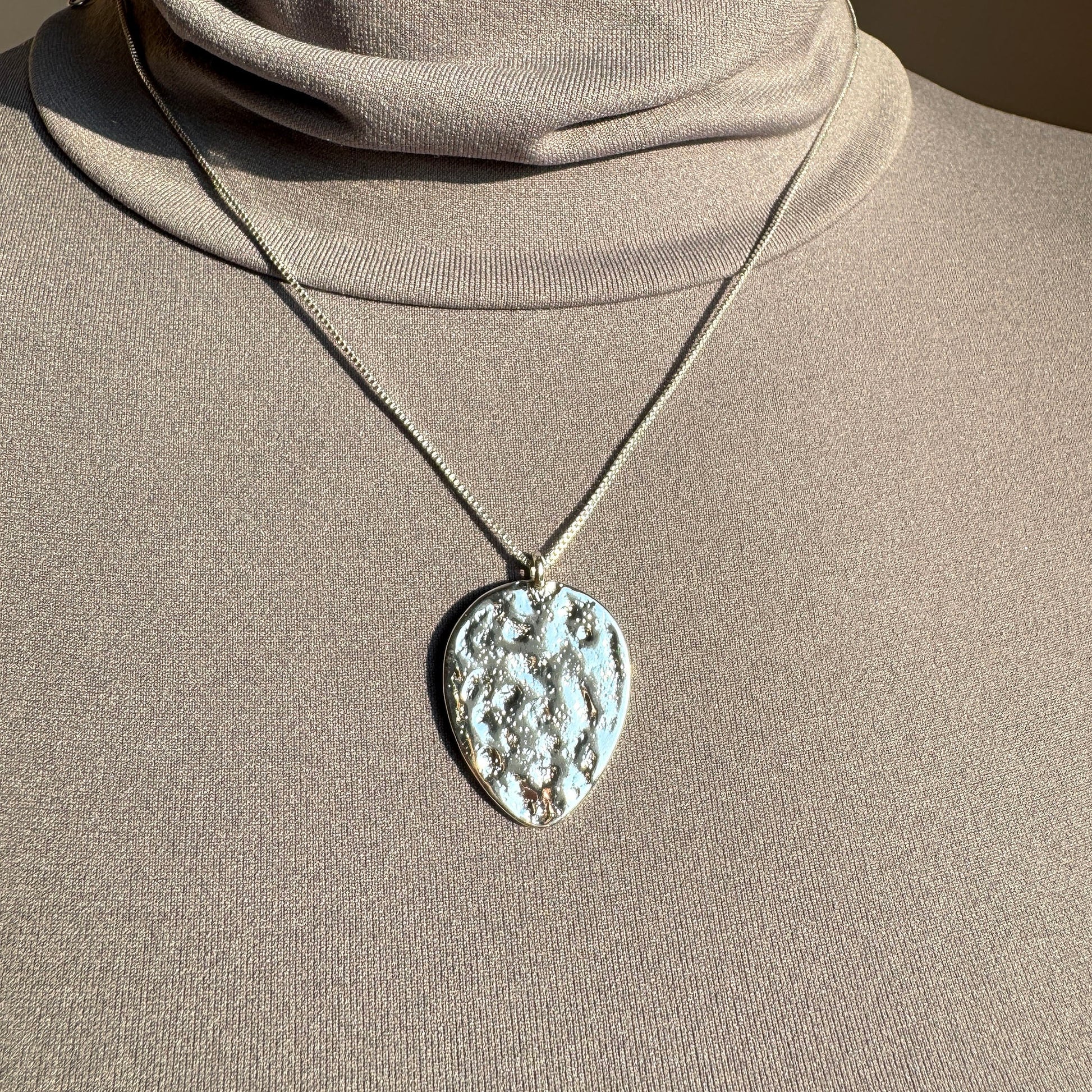 Pilgrim necklace with large textured medallion in silver tone worn on the neck