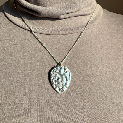 Pilgrim necklace with large textured medallion in silver tone worn on the neck