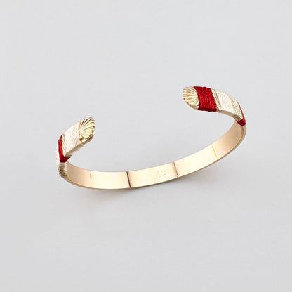 Pulsera Sonata con extremos envueltos en hilo y forma abierta dorada